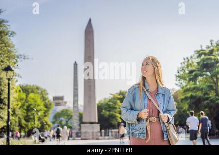 Femme touristique à Istanbul contre le fond de l'Obélisque de Theodosius est l'obélisque égyptien antique de Pharaon Thutmose III places dans le Banque D'Images