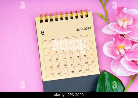 Juin 2023 Calendrier mensuel de bureau fait à partir de papier artisanal avec orchidée rose sur fond magnifique. Banque D'Images