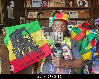 Kingston, Jamaïque. 29th mars 2023. Sur le terrain du Bob Marley Museum, Herman Davis, percussionniste du reggae de 79 ans, connu sous le nom de Bongo Herman, se trouve dans son stand, portant un drapeau avec l'apparence de Marley. Il y vend des enregistrements musicaux et des souvenirs et parle aux touristes de sa longue carrière musicale. (À dpa-Korr 'Catch a Fire': Quand le reggae est sorti dans le monde il y a 50 ans') Credit: Nick Kaiser/dpa/Alay Live News Banque D'Images