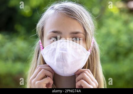 Fille (11) avec protection bouche-nez, Kiel, Schleswig-Holstein, Allemagne Banque D'Images