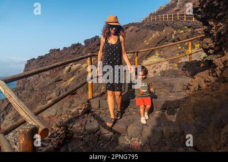 Coucher de soleil sur l'île El Hierro. Îles Canaries, mère et fils sur le chemin de la piscine naturelle de Charco Azul Banque D'Images