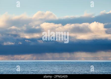 Les nuages de pluie de basse altitude se déllent au-dessus des eaux ouvertes de l'océan Atlantique bleu Banque D'Images