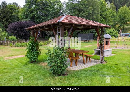 gazebo en bois et table sur l'herbe verte Banque D'Images