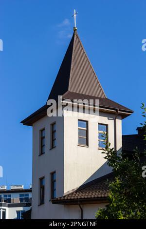 Maison avec nouveau toit en carreaux de métal brun et gouttière. Système de gouttière métallique, gouttière et tuyau de drainage extérieur. Banque D'Images