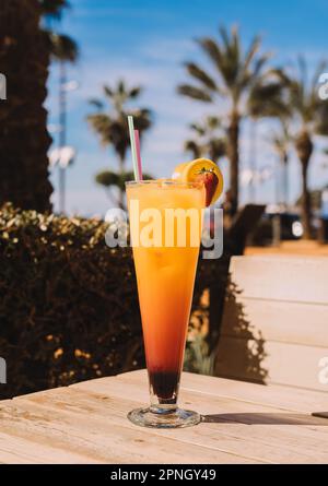 Un Tequila Sunrise est un cocktail coloré et fruité qui est typiquement fait avec la tequila, le jus d'orange, et le sirop de grenadine. Banque D'Images