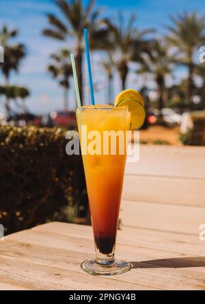 Un Tequila Sunrise est un cocktail coloré et fruité qui est typiquement fait avec la tequila, le jus d'orange, et le sirop de grenadine. Banque D'Images