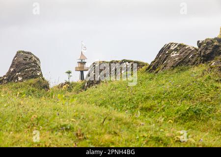 Vestmannaeyjar, Islande- août 2021 : petit phare noir dans une vallée verdoyante de l'île de Vestmannaeyjar, en Islande, Banque D'Images