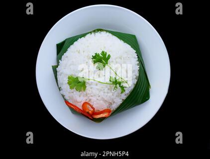 Riz blanc vietnamien en feuille de banane isolée sur fond noir pour un menu Banque D'Images