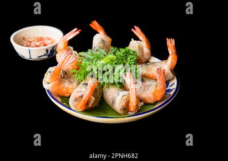 Rouleaux de printemps vietnamiens frits traditionnels avec crevettes et porc, papier de riz sur fond noir Banque D'Images