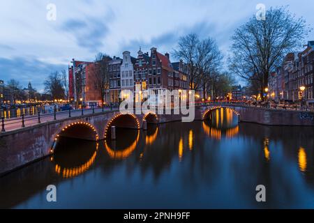 Les ponts s'illuminent à l'heure bleue du crépuscule à Amsterdam, Hollande, pays-Bas en avril - longue exposition Banque D'Images