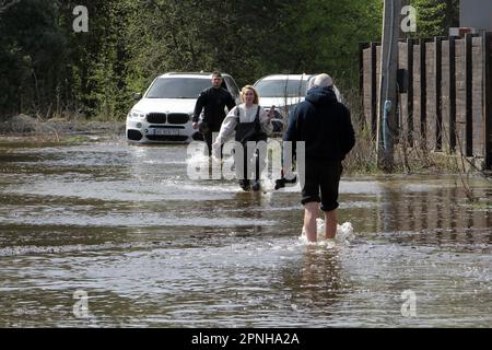 OBUKHIVKA, UKRAINE - 18 AVRIL 2023 - des gens se sont empais le long d'une rue inondée dans la colonie urbaine d'Obukhivka, région de Dnipropetrovsk, centre de l'Ukraine. Banque D'Images