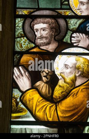 Les Apôtres, y compris Judas avec sac d'argent contenant des pièces d'argent et un halo gris, dans une vitrelle d'église – détail de la dernière fenêtre de la Cène – à Cheltenham Minster, St Mary's. Cheltenham, Gloucestershire. ROYAUME-UNI. (134). Banque D'Images