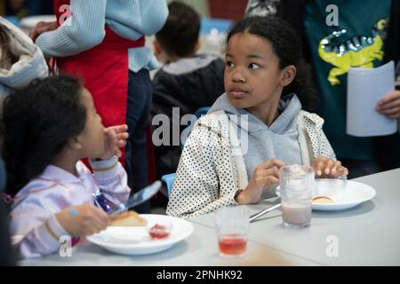 Eat, Allemagne. 19th avril 2023. Une écolière distribue du pain avec de la confiture, le projet Brotzeit est destiné à permettre aux enfants de commencer la journée d'école avec le petit déjeuner, l'actrice Uschi GLAS, présidente du projet brotzeit, visite l'école Bischof von Ketteler d'Essen, 19 avril 2023 Credit: dpa/Alamy Live News Banque D'Images