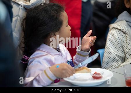 Eat, Allemagne. 19th avril 2023. Une écolière distribue du pain avec de la confiture, le projet Brotzeit est destiné à permettre aux enfants de commencer la journée d'école avec le petit déjeuner, l'actrice Uschi GLAS, présidente du projet brotzeit, visite l'école Bischof von Ketteler d'Essen, 19 avril 2023 Credit: dpa/Alamy Live News Banque D'Images