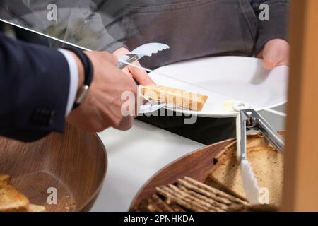Eat, Allemagne. 19th avril 2023. Les élèves au petit-déjeuner, s'aider au buffet, avec des volontaires, le projet Brotzeit est destiné à permettre aux enfants de commencer la journée d'école avec le petit-déjeuner, l'actrice Uschi GLAS, présidente du projet brotzeit, visite l'école Bischof von Ketteler d'Essen, 19 avril 2023, crédit: dpa/Alay Live News Banque D'Images