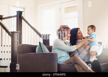 Trois générations de bonheur sous un même toit. une adorable petite fille se liant à sa mère et à sa grand-mère à la maison. Banque D'Images