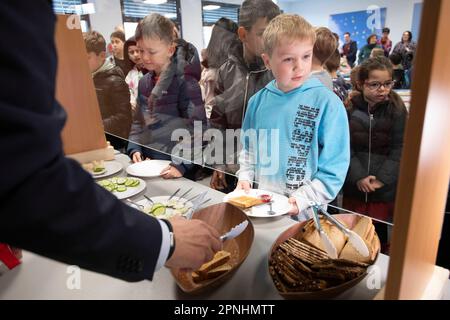 Eat, Allemagne. 19th avril 2023. Les élèves au petit-déjeuner, s'aider au buffet, avec des volontaires, le projet Brotzeit est destiné à permettre aux enfants de commencer la journée d'école avec le petit-déjeuner, l'actrice Uschi GLAS, présidente du projet brotzeit, visite l'école Bischof von Ketteler d'Essen, 19 avril 2023, crédit: dpa/Alay Live News Banque D'Images