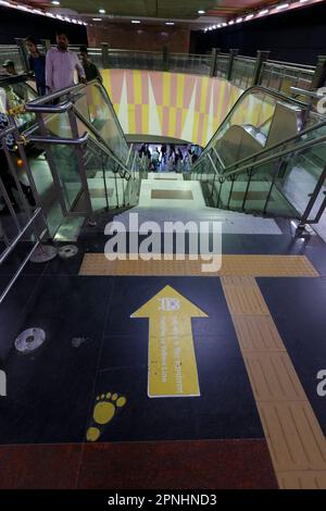Ligne jaune direction panneau sur le sol dans la station de métro Dilli Haat - INA à Delhi, Inde Banque D'Images