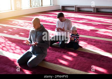 Islamique, communauté ou peuple en priant avec un garçon ou un enfant pour le soutien des dieux, la paix spirituelle pendant le ramadan Banque D'Images