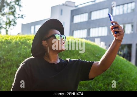 Femme africaine attirante prenant le selfie dans la rue portant des lunettes - concept millénaire et génération z Banque D'Images