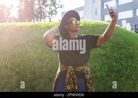 Femme africaine attirante prenant le selfie dans la rue portant des lunettes - concept millénaire et génération z Banque D'Images