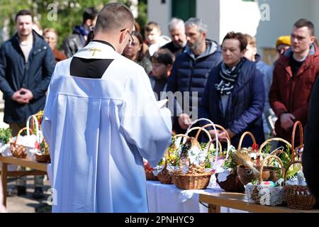 Laski près de Varsovie Pologne - Un prêtre catholique romain bénissant des paniers de nourriture pendant un service traditionnel de Pâques en avril 2023 Banque D'Images