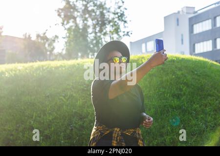 Femme africaine attirante prenant le selfie dans la rue portant des lunettes - concept millénaire et génération z Banque D'Images