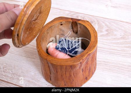 Boîte en bois avec fils et aiguilles gros plan Banque D'Images