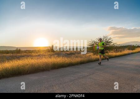 Triathlète en équipement professionnel courant tôt le matin, se préparant pour un marathon, dévouement au sport et prêt à relever les défis de Banque D'Images