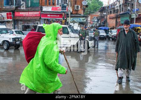 19 avril 2023, Srinagar, Jammu-et-Cachemire, Inde : les amateurs de kashmiri se promèneront devant les troopeurs paramilitaires indiens qui se tiennent sur la garde pendant les pluies en prévision du festival musulman Eid-al-Fitr sur un marché local à Srinagar. Les marchés du monde musulman sont témoins d’une énorme ruée vers les achats en préparation à l’Eid al-Fitr, une célébration qui marque la fin du mois musulman de jeûne du Ramadan. (Credit image: © Faisal Bashir/SOPA Images via ZUMA Press Wire) USAGE ÉDITORIAL SEULEMENT! Non destiné À un usage commercial ! Banque D'Images