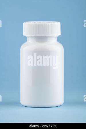 Contenant médical blanc de pilules sur fond bleu clair. Médicaments et pilules de supplément de santé en médecine bouteille blanche soins de santé et médical. Banque D'Images