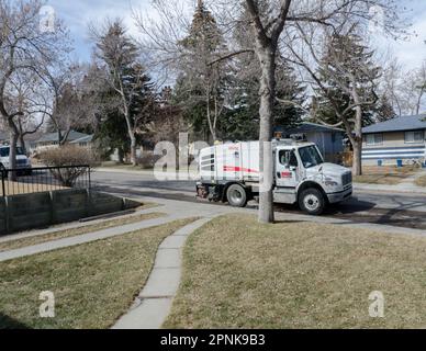 Au printemps, on peut voir des flottes de balayeuses de rue nettoyer des rues résidentielles à Calgary, en Alberta. Noter les roues directrices jumelées. Banque D'Images