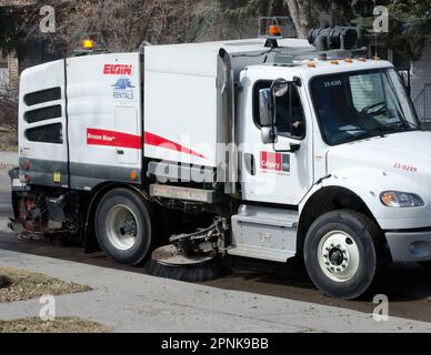 Au printemps, on peut voir des flottes de balayeuses de rue nettoyer des rues résidentielles à Calgary, en Alberta. Noter les roues directrices jumelées. Banque D'Images