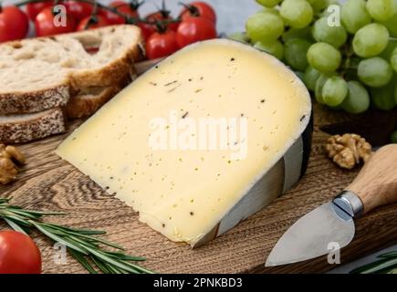 а morceau de fromage à la truffe sur une planche à découper Banque D'Images