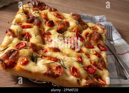 Focaccia italien de Pugliese maison avec romarin et huile sur bois rustique. Banque D'Images