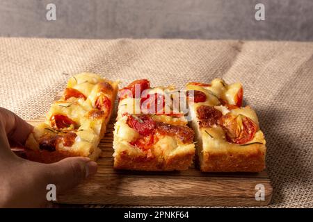 Focaccia italien de Pugliese maison avec romarin et huile sur bois rustique. Banque D'Images