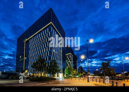 Varsovie, Pologne - juillet 2022 : immeubles de bureaux lumineux, situés à côté de la gare de Warszawa Zachodnia, vus de nuit pendant l'heure bleue Banque D'Images