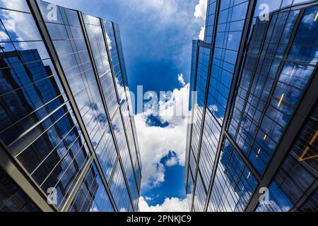 Varsovie, Pologne - juillet 2022: Vue d'en dessous sur les bâtiments en verre de Proximo à Varsovie se reflétant l'un dans l'autre Banque D'Images