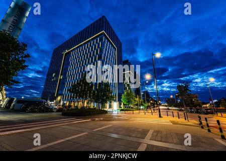 Varsovie, Pologne - juillet 2022 : immeubles de bureaux lumineux, situés à côté de la gare de Warszawa Zachodnia, vus de nuit pendant l'heure bleue Banque D'Images