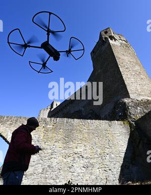 PRODUCTION - 05 avril 2023, Hesse, Hohenstein: Werner Maziborsky de la société Linsinger ZT de St. Johann im Pongau (Autriche) lance un drone pour étudier numériquement les ruines du château de Hohenstein près de Bad Schwalbach dans la région de Taunus. Le Landesbetrieb Bau und Immobilien Hessen (LBIH) a déjà mis en œuvre de grandes parties d'un vaste projet de rénovation au monument culturel de la vallée de l'Aartal. Pour les prochaines étapes de restauration, le complexe du château doit être inspecté numériquement ce printemps. (À dpa: 'La technologie de dern rencontre les vieux murs - l'étude de château avec le drone". Photo: Arne Dedert/dpa Banque D'Images