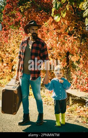 Raconter des histoires sur les temps passés. Père avec valise et son fils. Un papa barbu parle de voyage à son fils. Voyageur avec beaucoup d'expérience. Esprit de Banque D'Images