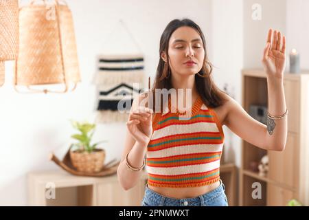 Jeune femme avec un espace de nettoyage de l'encens à la maison Banque D'Images