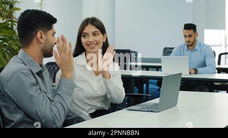 Les partenaires d'affaires indiens et caucasiens discutent de nouveau projet lors d'une réunion en travaillant avec un collègue à l'aide d'un ordinateur portable, en interagissant et en partageant leurs pensées développer des idées donner Banque D'Images