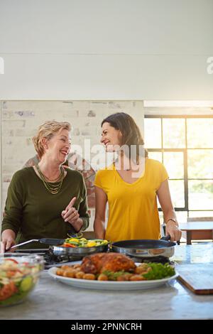 Theres un ingrédient secret que je ne suis pas prêt à partager. une femme âgée et sa fille cuisinant dans la cuisine. Banque D'Images