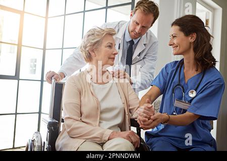 Votre santé est notre priorité numéro un. une femme âgée dans la maison de retraite avec son médecin et son infirmière. Banque D'Images