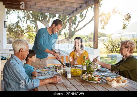 Maintenir la tradition du déjeuner du dimanche en famille. une famille qui apprécie un repas à la maison. Banque D'Images