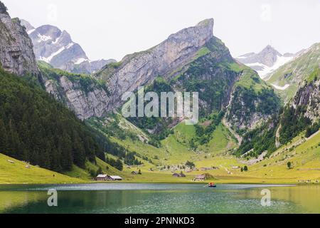 Deux musiciens soufflent l'alborn dans un bateau, lac de montagne Seealpsee, Wasserauen, canton d'Appenzell Innerrhoden, Suisse Banque D'Images