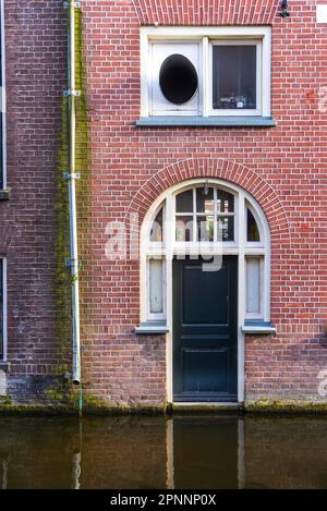 19 avril 2023, Delft, pays-Bas, rue du quartier central avec restaurants, canal, bâtiments en briques et vélos le jour nuageux à Delft Banque D'Images