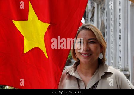 Une femme ferme le drapeau rouge du Vietnam avec une étoile jaune. Hanoï. Vietnam. Banque D'Images