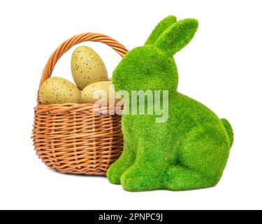 Statuette de lapin de Pâques et panier avec œufs de pâques isolés sur fond blanc avec passe-cheveux. Banque D'Images